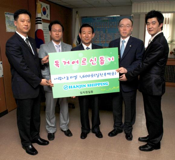 한진해운의 김영민 부사장이 독거노인 지원을 위해 쌀 1,600포를 관련구청 공무원에게 전달하고 있다.