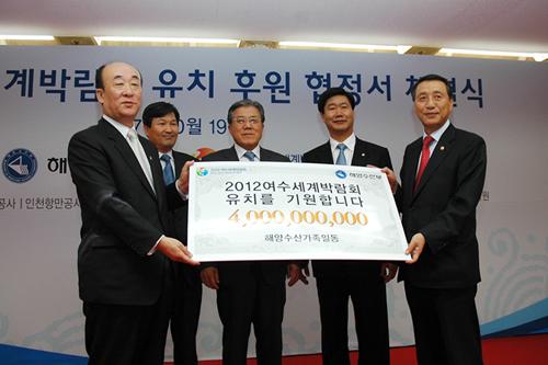 강무현 장관이 해양수산단체의 후원금 40억원을 유치위원회 이윤복 사무총장에게 전달하고 있다